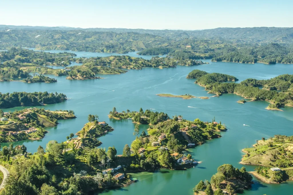 Green islands scattered across the blue Guatapé reservoir, seen from above